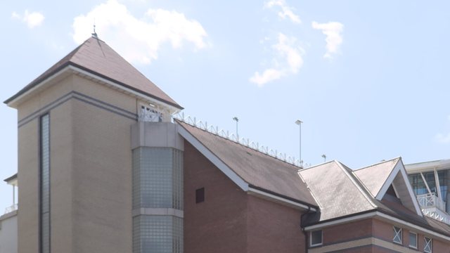 The Radcliffe Road Stand at Trent Bridge, with its brick tower and pitched roofs beneath a blue sky.