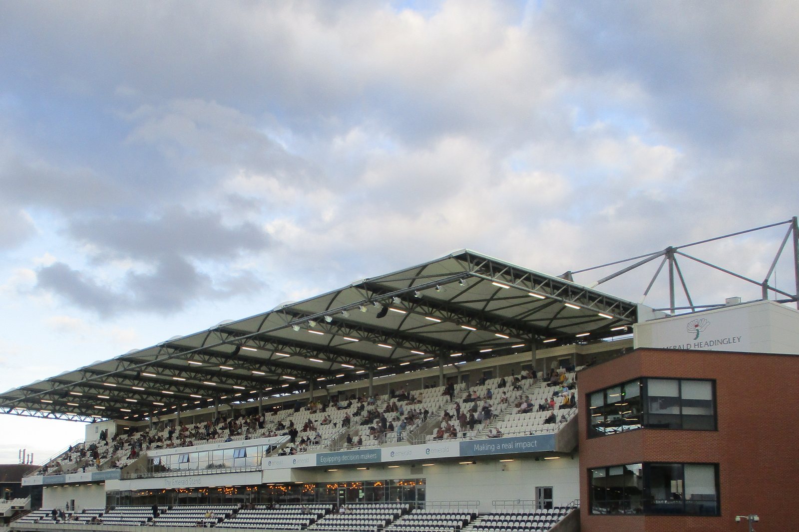 The rebuilt shared stand at Headingley, with a wide cantilever roof above white cricket seating.